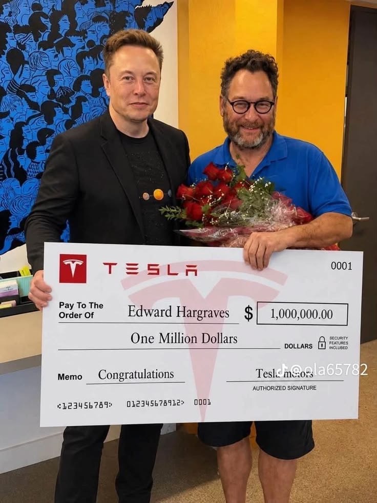 Two people holding flowers and a large presentation check
