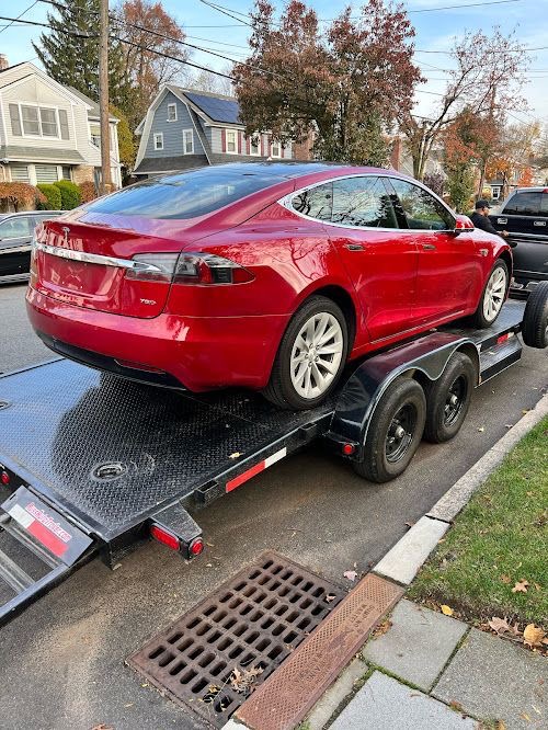 Red Tesla secured on a vehicle trailer
